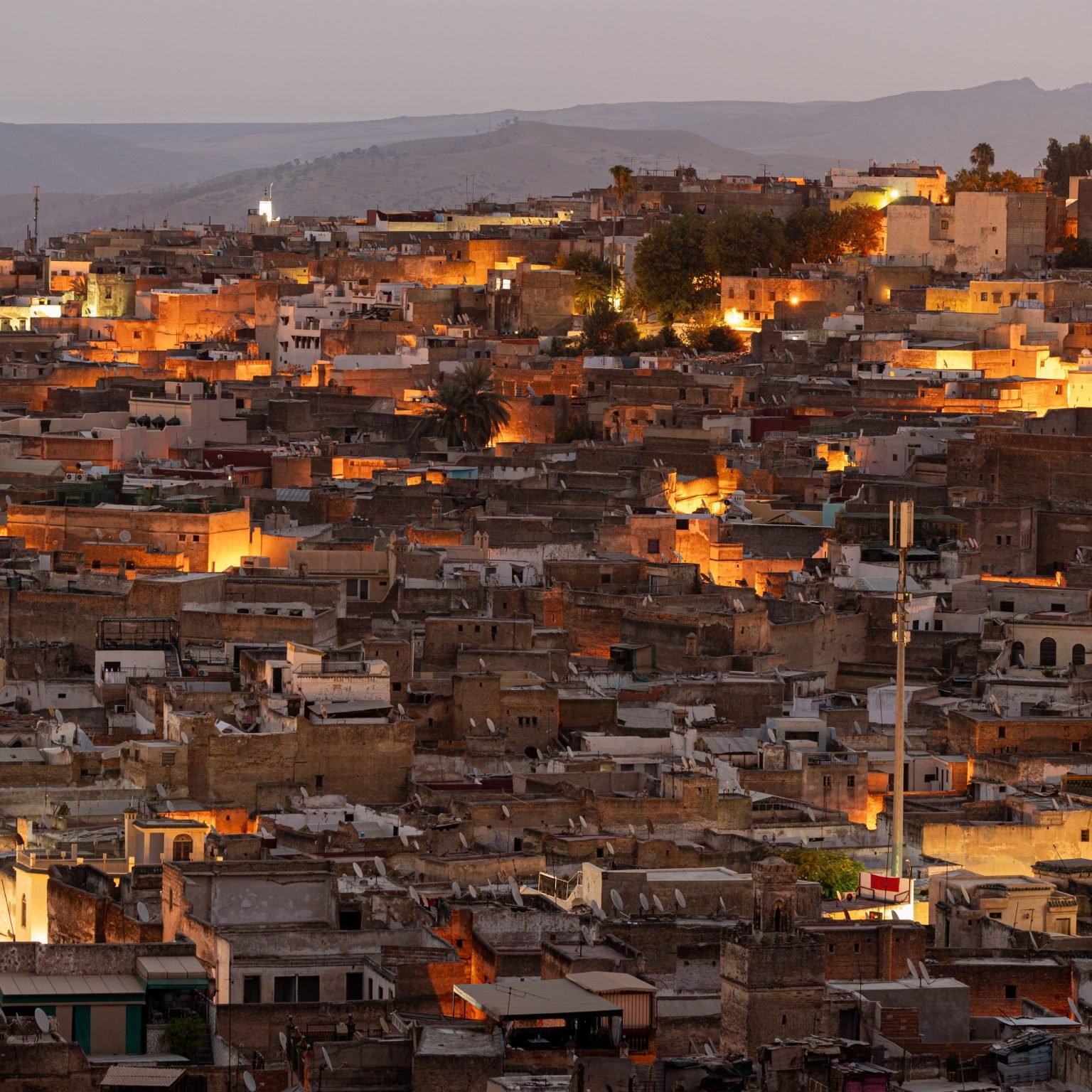 The city of Fez illuminated by early morning light, showcasing historic buildings and structures.